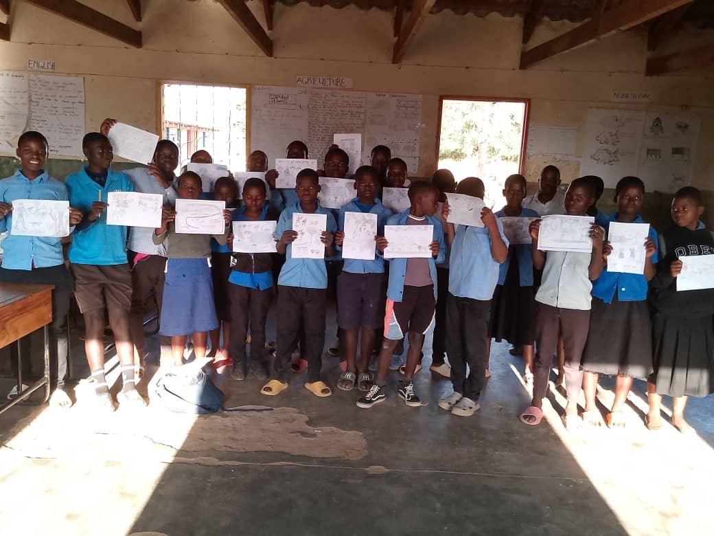A Kasungu class holding up their finished drawings together